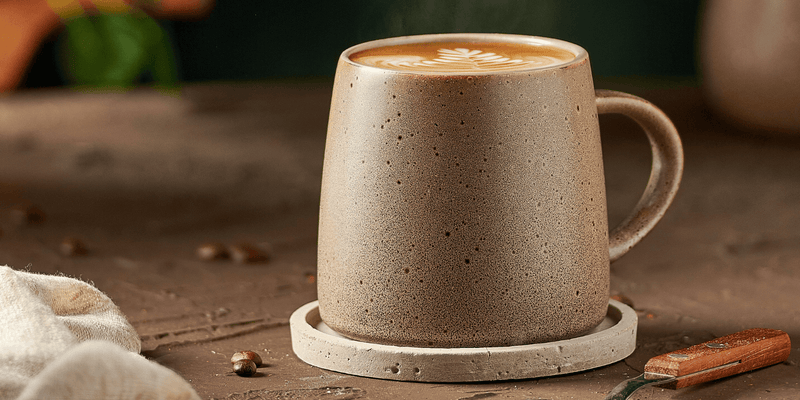 Dos tazas de café con diseño de hojas en el borde.